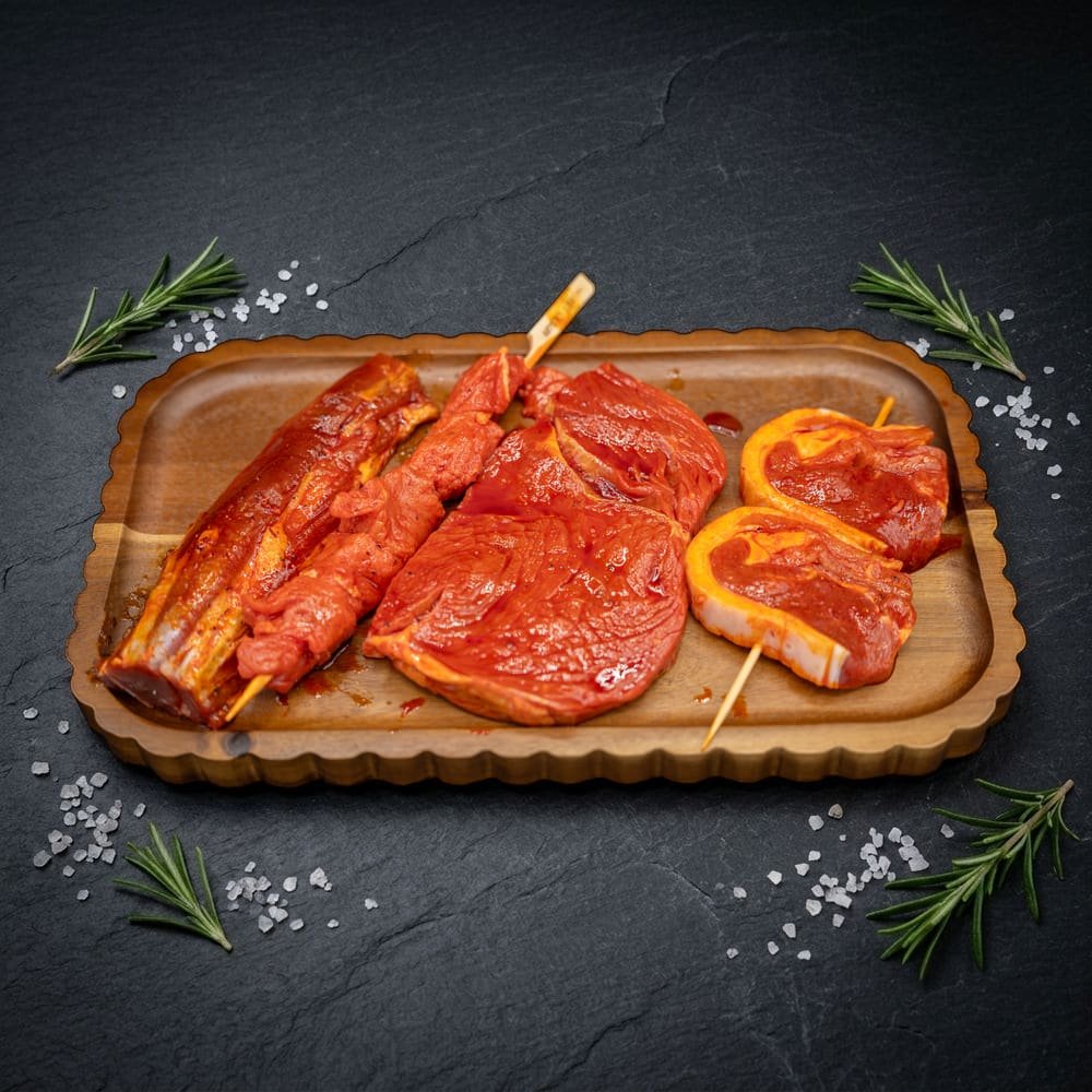 BBQ BOX 3 – Rund & Lam in rode marinade: lamsfilet, runds saté, entrecote en lamsbeyti op houten plank