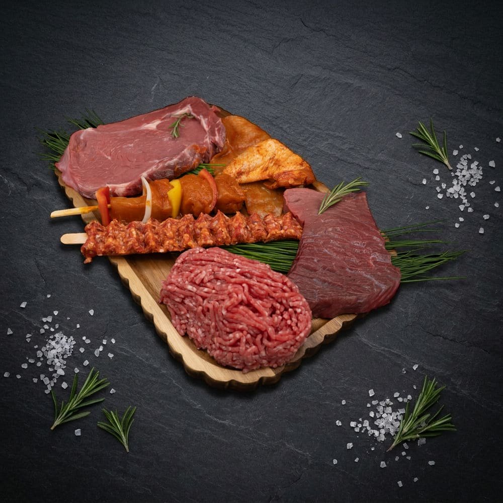 Inhoud Premium Weekpakket: entrecote, kipfilet, kippenvleugel, kip saté met groenten, Adana kebap, rundergehakt en biefstuk op houten plank