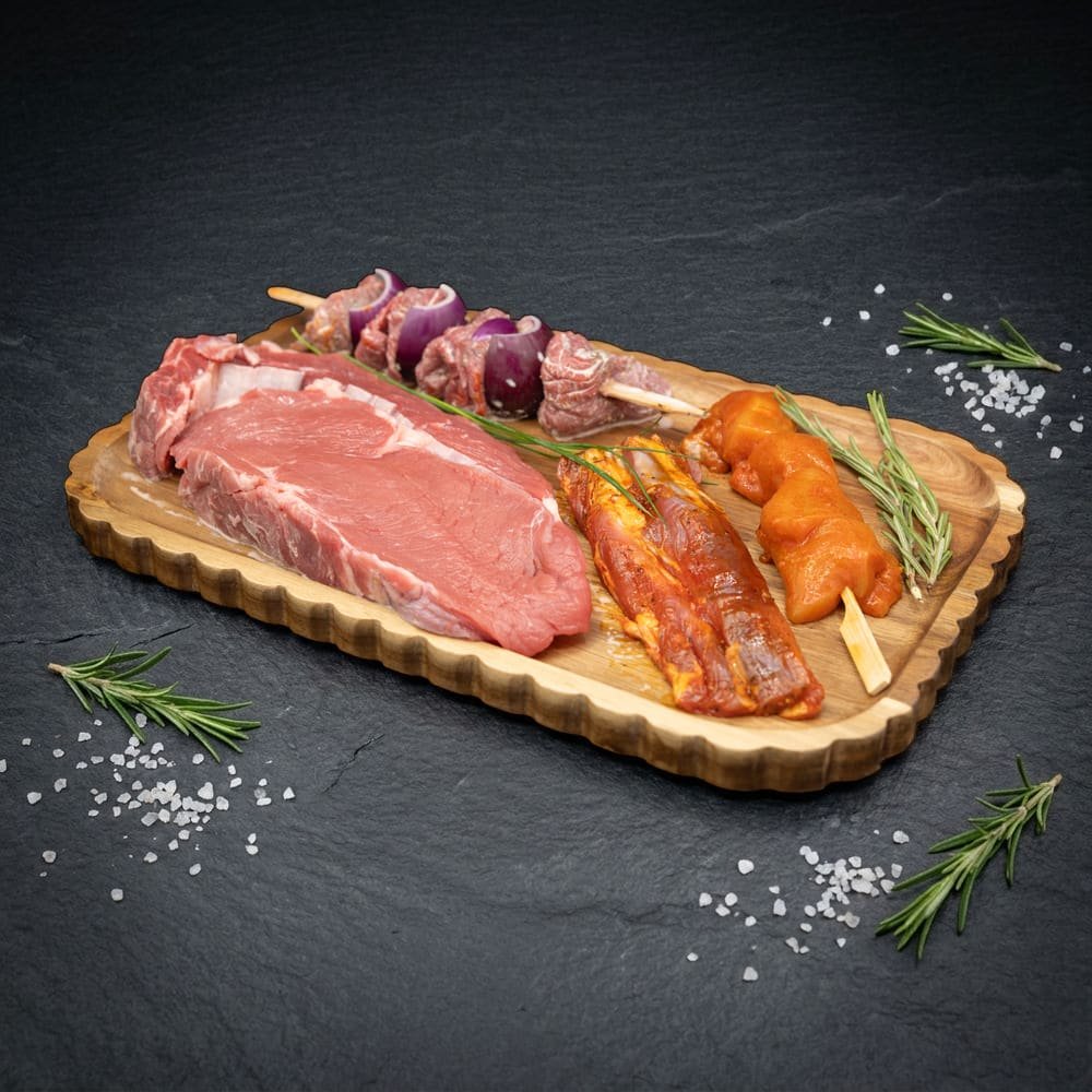Inhoud VIP BBQ BOX – Deluxe: entrecote, runds shashlik, gemarineerd lamsvlees en kip saté op houten plank